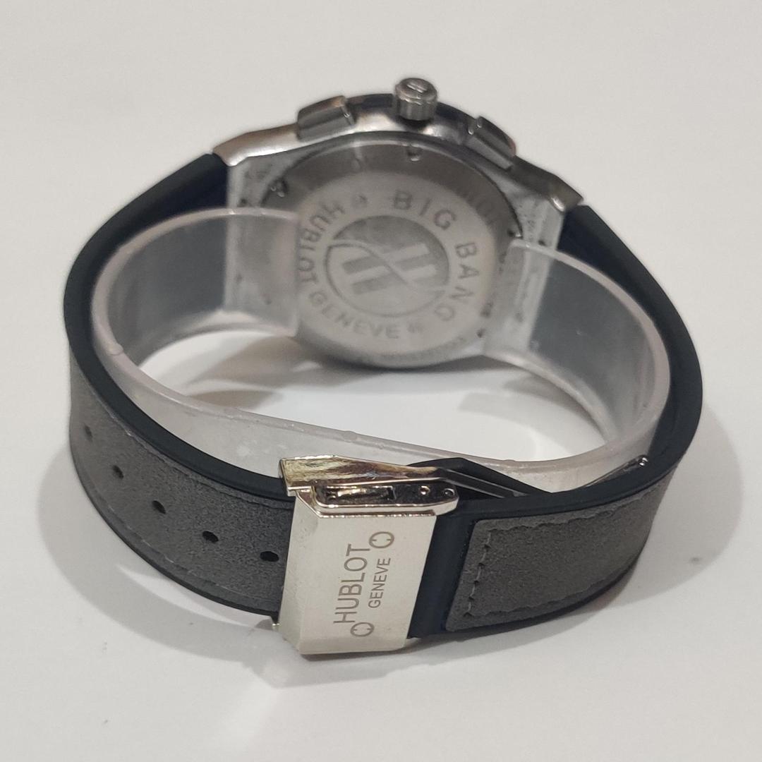 Hublot watch with black strap and silver case on a white background