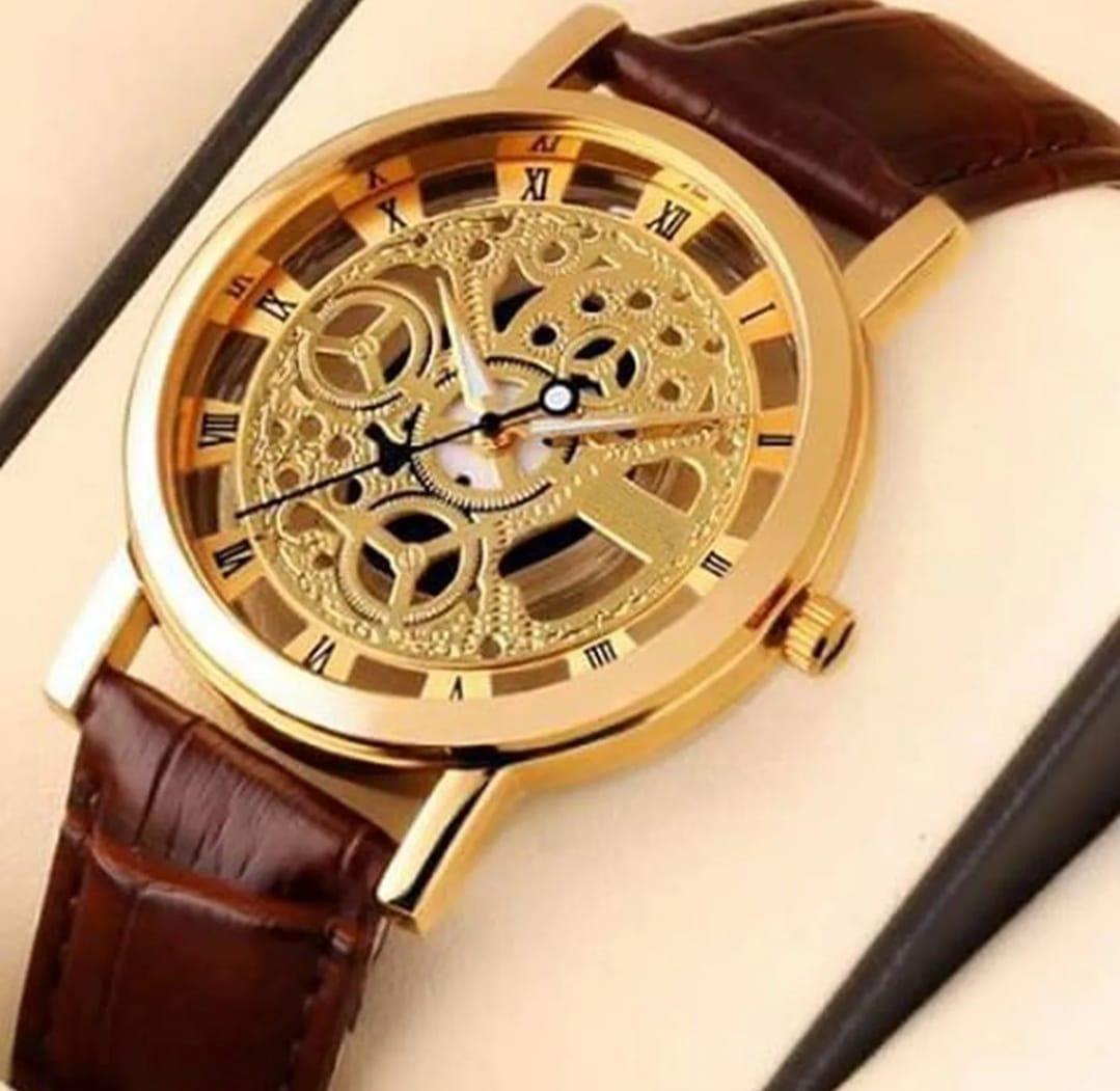 Gold wristwatch with brown leather strap on a beige background
