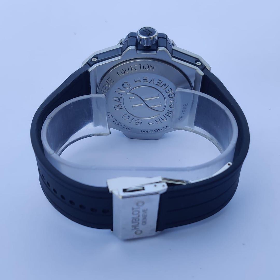 Black watch with silver case and band on a light blue background