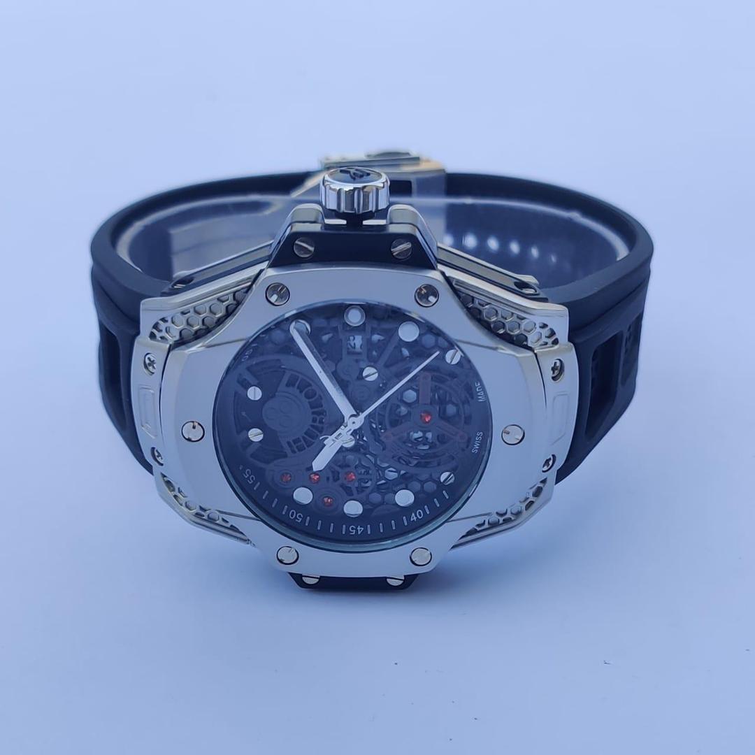 Luxury watch with black strap and silver case on a light blue background