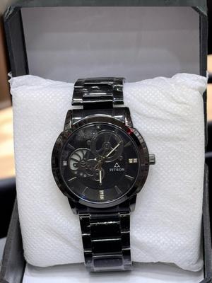 Black wristwatch with detailed face on a white cushion inside a box