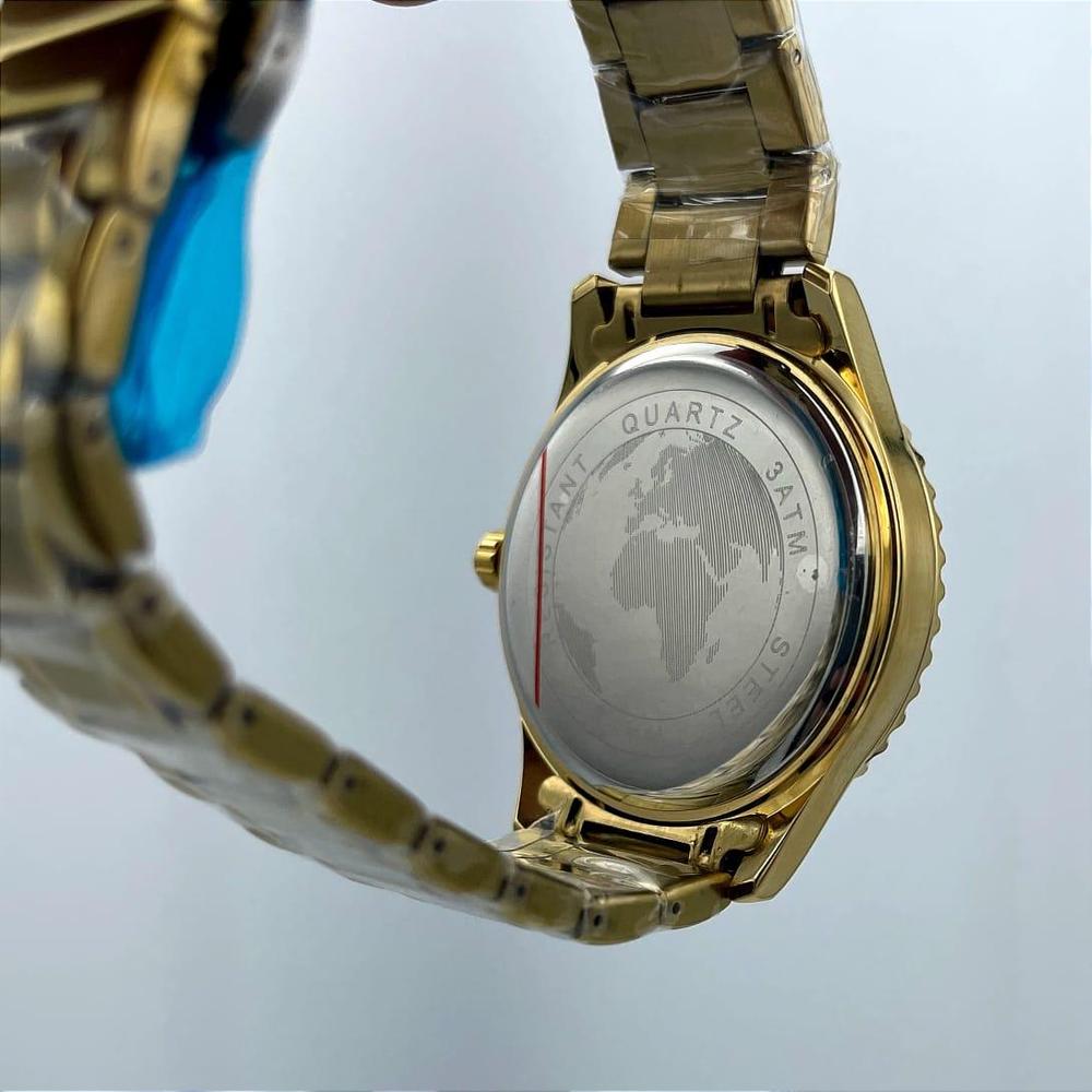Gold watch with a detailed back cover on a light gray background