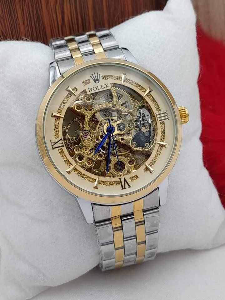 Luxury watch with a gold and silver band on a wrist, brand visible