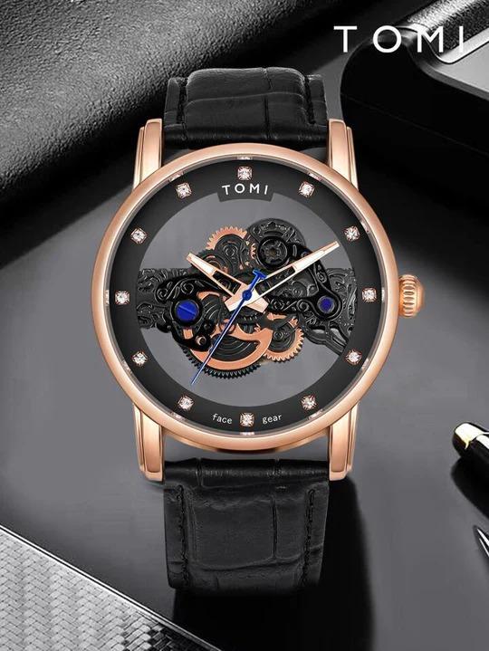 Luxury watch with black strap and rose gold case on a dark surface, brand 'TOMI' visible.