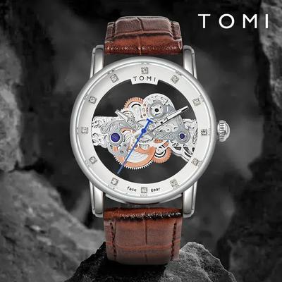 Tomi watch with brown leather strap and visible mechanical components on a dark background