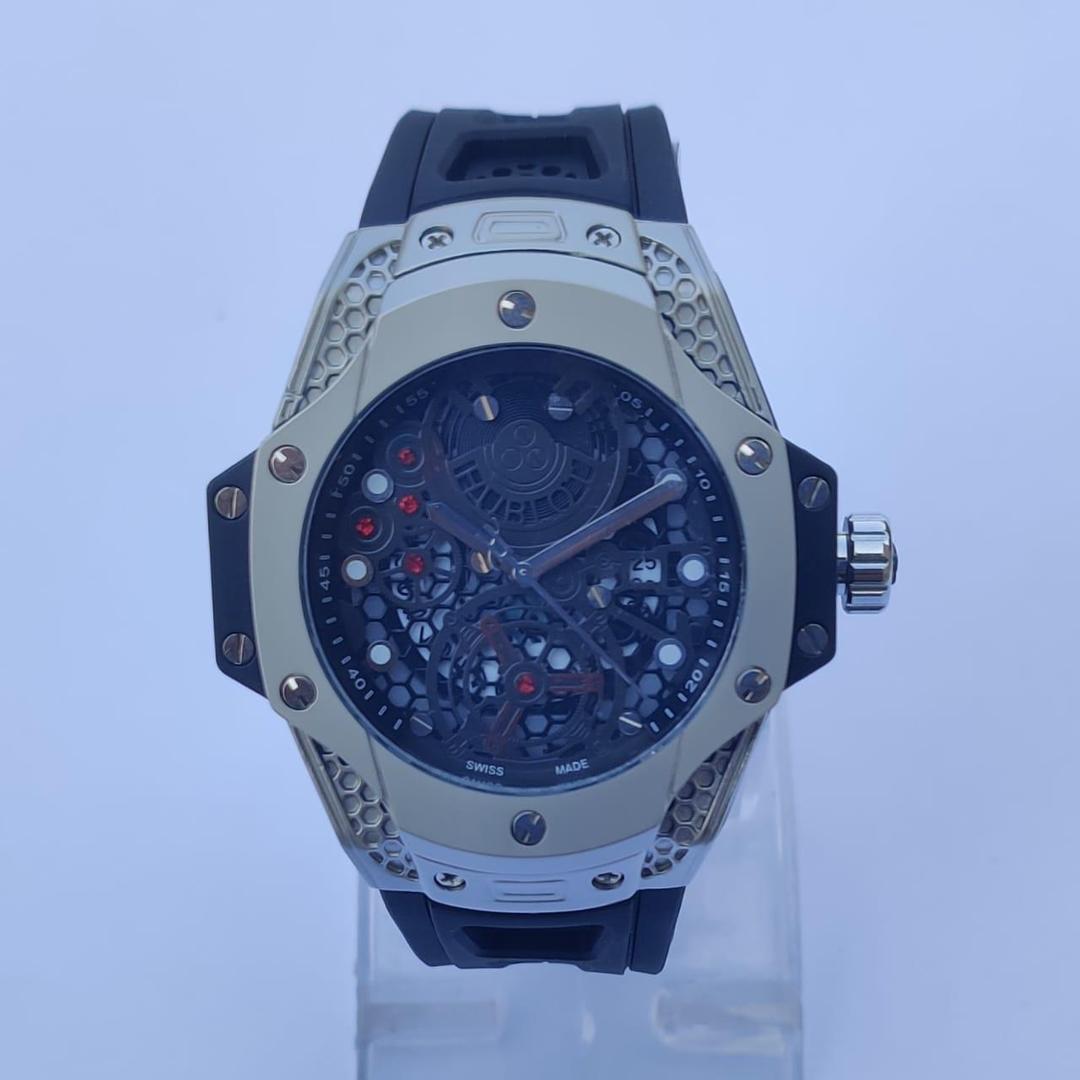 Luxury watch with blue strap and silver case on a light blue background